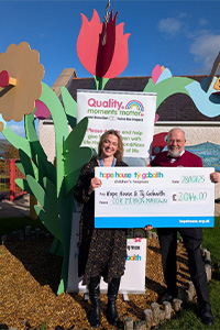 Geoff Templeton holding onto a cheque of £2,550 to donate to Ty Gobaith